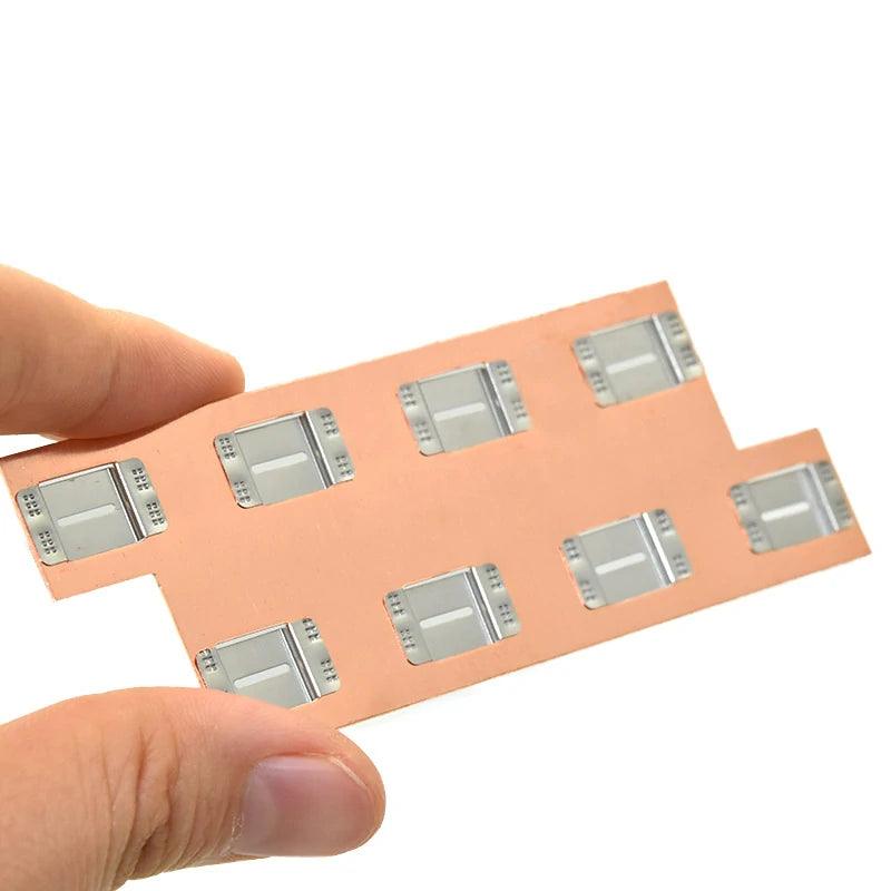 Close-up of a precision-cut copper battery tab with nickel-plated contact pads, used in 18650 and 21700 lithium-ion battery packs.